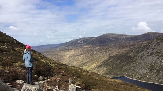 a woman looking at a view of the mourne mountainss
