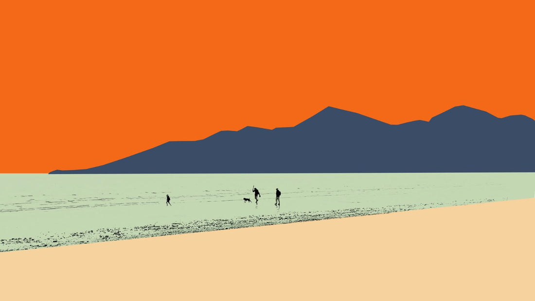 canvas print of a group of people walking on a beach at the waters edge with mountains in the background